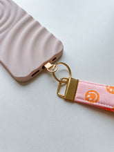 Load image into Gallery viewer, Phone Wrist Strap - pink & orange smileys