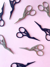 Load image into Gallery viewer, Black and silver stork embroidery scissors on pink background
